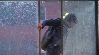 Movie still from “Foxfire” (1996), directed by Annette Haywood-Carter – A man in black jacket standing in front of a window; Wide shot, Low angle
