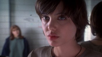 Movie still from “Foxfire” (1996), directed by Annette Haywood-Carter – A person with short brown hair; Close Up shot, Low angle