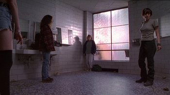 Movie still from “Foxfire” (1996), directed by Annette Haywood-Carter – Two people standing in a room next to a window; Wide shot, Low angle