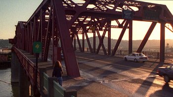 Movie still from “Foxfire” (1996), directed by Annette Haywood-Carter – A woman crossing a bridge over a river; Extreme Wide shot, High angle