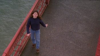 Movie still from “Foxfire” (1996), directed by Annette Haywood-Carter – A woman standing on a bridge near a body of water; Wide shot, High angle