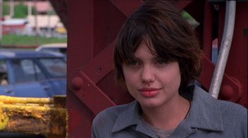 Movie still from “Foxfire” (1996), directed by Annette Haywood-Carter – A woman with short brown hair is posing for a picture; Close Up shot, Low angle