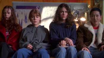Movie still from “Foxfire” (1996), directed by Annette Haywood-Carter – Two young women sitting on a couch in a room; Medium shot, High angle