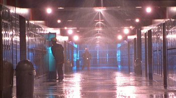 Movie still from “Foxfire” (1996), directed by Annette Haywood-Carter – A man standing in a hallway under a rain shower at night; Extreme Wide shot, High angle