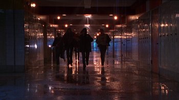 Movie still from “Foxfire” (1996), directed by Annette Haywood-Carter – A group of people walking down a hallway at night; Wide shot, High angle