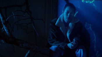 Movie still from “Foxfire” (1996), directed by Annette Haywood-Carter – A man sitting on a wall in the dark; Medium shot, High angle