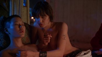 Movie still from “Foxfire” (1996), directed by Annette Haywood-Carter – A woman sitting on top of a bed next to a man; Medium shot, Over the shoulder angle