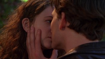 Movie still from “Foxfire” (1996), directed by Annette Haywood-Carter – A man and a woman are kissing in a park; Close Up shot, Over the shoulder angle