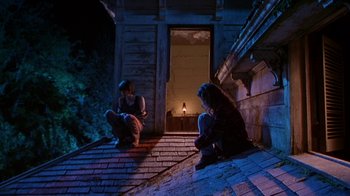 Movie still from “Foxfire” (1996), directed by Annette Haywood-Carter – Two people sitting on the steps of a house at night; Wide shot, Low angle