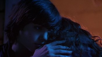 Movie still from “Foxfire” (1996), directed by Annette Haywood-Carter – A woman is holding her head down in a dark room; Close Up shot, Over the shoulder angle