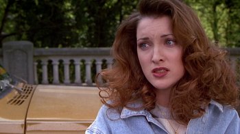 Movie still from “Foxfire” (1996), directed by Annette Haywood-Carter – A person sitting on a bench; Close Up shot, Over the shoulder angle