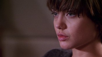 Movie still from “Foxfire” (1996), directed by Annette Haywood-Carter – A woman's face in a dark room; Close Up shot, Over the shoulder angle