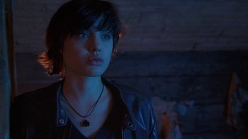 Movie still from “Foxfire” (1996), directed by Annette Haywood-Carter – A woman wearing a black leather jacket and a black necklace; Close Up shot, Over the shoulder angle