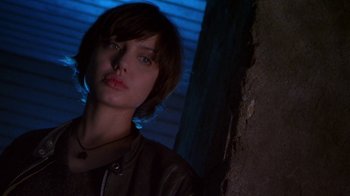 Movie still from “Foxfire” (1996), directed by Annette Haywood-Carter – A woman with short brown hair wearing a leather jacket; Close Up shot, Low angle