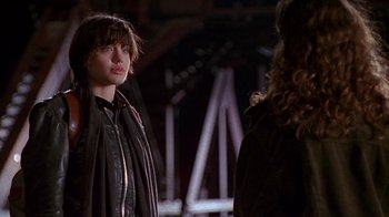 Movie still from “Foxfire” (1996), directed by Annette Haywood-Carter – A woman standing next to another woman wearing a brown jacket; Medium shot, Over the shoulder angle