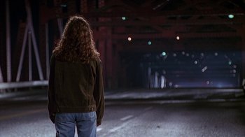 Movie still from “Foxfire” (1996), directed by Annette Haywood-Carter – A woman standing in the middle of an empty street; Wide shot, Over the shoulder angle
