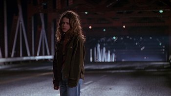 Movie still from “Foxfire” (1996), directed by Annette Haywood-Carter – A woman standing on a street at night; Medium shot, Low angle