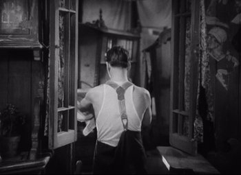 Movie still from “Freaks” (1932), directed by Tod Browning – A man wearing a white shirt and a black tie; Medium shot, Low angle