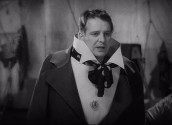 Movie still from “Freaks” (1932), directed by Tod Browning – A black and white photo of a man wearing a neck tie; Close Up shot, Low angle