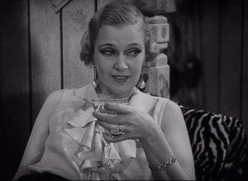 Movie still from “Freaks” (1932), directed by Tod Browning – An old photo of a woman holding a glass of wine; Close Up shot, High angle