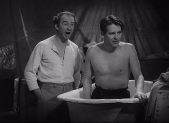 Movie still from “Freaks” (1932), directed by Tod Browning – Two men are standing next to each other in a bathtub; Medium shot, Over the shoulder angle