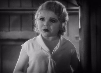Movie still from “Freaks” (1932), directed by Tod Browning – A little girl is standing in front of a wall; Close Up shot, High angle
