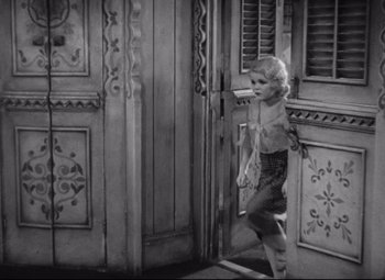 Movie still from “Freaks” (1932), directed by Tod Browning – A young girl walking through an open door; Wide shot, High angle