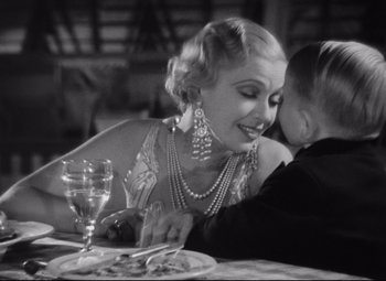Movie still from “Freaks” (1932), directed by Tod Browning – An older woman and a young boy sitting at a dinner table; Close Up shot, High angle