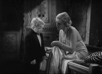 Movie still from “Freaks” (1932), directed by Tod Browning – An old photo of a woman and a young boy; Medium shot, High angle