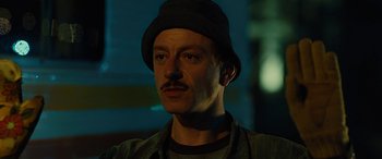 Movie still from “Free Fire” (2016), directed by Ben Wheatley – A person wearing a hat; Close Up shot, Low angle