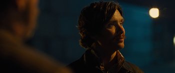 Movie still from “Free Fire” (2016), directed by Ben Wheatley – A person with long brown hair; Close Up shot, Over the shoulder angle