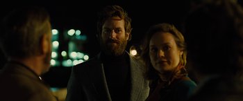 Movie still from “Free Fire” (2016), directed by Ben Wheatley – A man and a woman standing next to each other in the dark; Close Up shot, Low angle