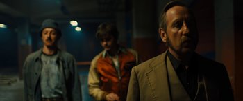 Movie still from “Free Fire” (2016), directed by Ben Wheatley – A man in a brown jacket and a man in a brown jacket; Medium shot, Over the shoulder angle