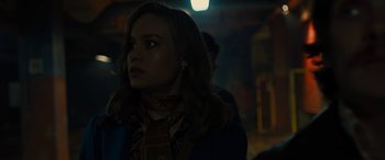 Movie still from “Free Fire” (2016), directed by Ben Wheatley – A woman with long blonde hair wearing a scarf; Close Up shot, Over the shoulder angle
