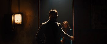 Movie still from “Free Fire” (2016), directed by Ben Wheatley – A man and a woman are standing in a doorway; Medium shot, Low angle