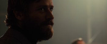 Movie still from “Free Fire” (2016), directed by Ben Wheatley – A person with a beard; Close Up shot, Over the shoulder angle