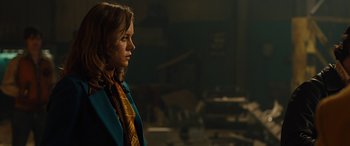 Movie still from “Free Fire” (2016), directed by Ben Wheatley – A woman in a blue jacket and a yellow tie; Medium shot, Over the shoulder angle