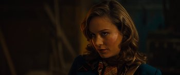 Movie still from “Free Fire” (2016), directed by Ben Wheatley – A beautiful woman with long brown hair wearing a blue shirt; Close Up shot, Over the shoulder angle
