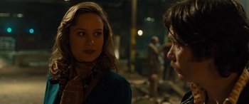 Movie still from “Free Fire” (2016), directed by Ben Wheatley – A woman standing next to a man on a street at night; Close Up shot, Over the shoulder angle