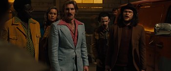 Movie still from “Free Fire” (2016), directed by Ben Wheatley – A group of people standing next to each other in a room; Medium shot, Low angle