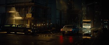 Movie still from “Free Fire” (2016), directed by Ben Wheatley – A car parked on the side of the road at night; Extreme Wide shot, Low angle