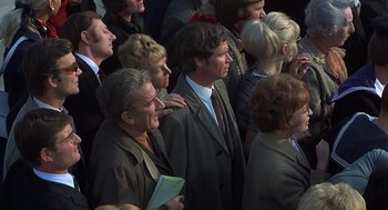 Movie still from “Frenzy” (1972), directed by Alfred Hitchcock – A group of people standing around each other in a crowd; Medium shot, High angle
