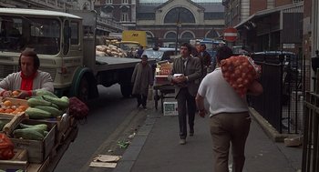Movie still from “Frenzy” (1972), directed by Alfred Hitchcock – A group of people walking down a street; Wide shot, Over the shoulder angle