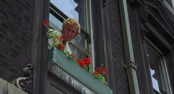 Movie still from “Frenzy” (1972), directed by Alfred Hitchcock – An old man looking out of a window with red flowers; Close Up shot, Low angle