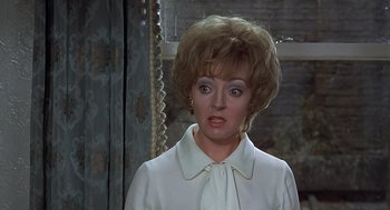 Movie still from “Frenzy” (1972), directed by Alfred Hitchcock – An older woman in a white dress looking at the camera; Close Up shot, Over the shoulder angle