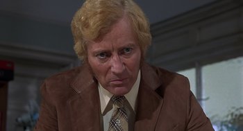 Movie still from “Frenzy” (1972), directed by Alfred Hitchcock – An older man in a brown suit and tie; Close Up shot, Low angle