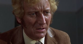 Movie still from “Frenzy” (1972), directed by Alfred Hitchcock – A person wearing a suit and tie; Close Up shot, Low angle