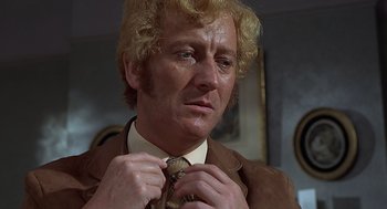 Movie still from “Frenzy” (1972), directed by Alfred Hitchcock – A person tying a tie; Close Up shot, Low angle