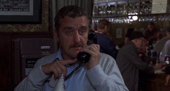Movie still from “Frenzy” (1972), directed by Alfred Hitchcock – A man holding a phone up to his ear; Close Up shot, Low angle