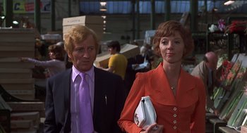Movie still from “Frenzy” (1972), directed by Alfred Hitchcock – A man and a woman standing next to each other; Medium shot, Low angle